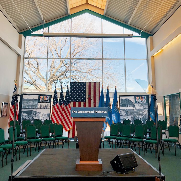 Large window sits behind a podium and American Flag