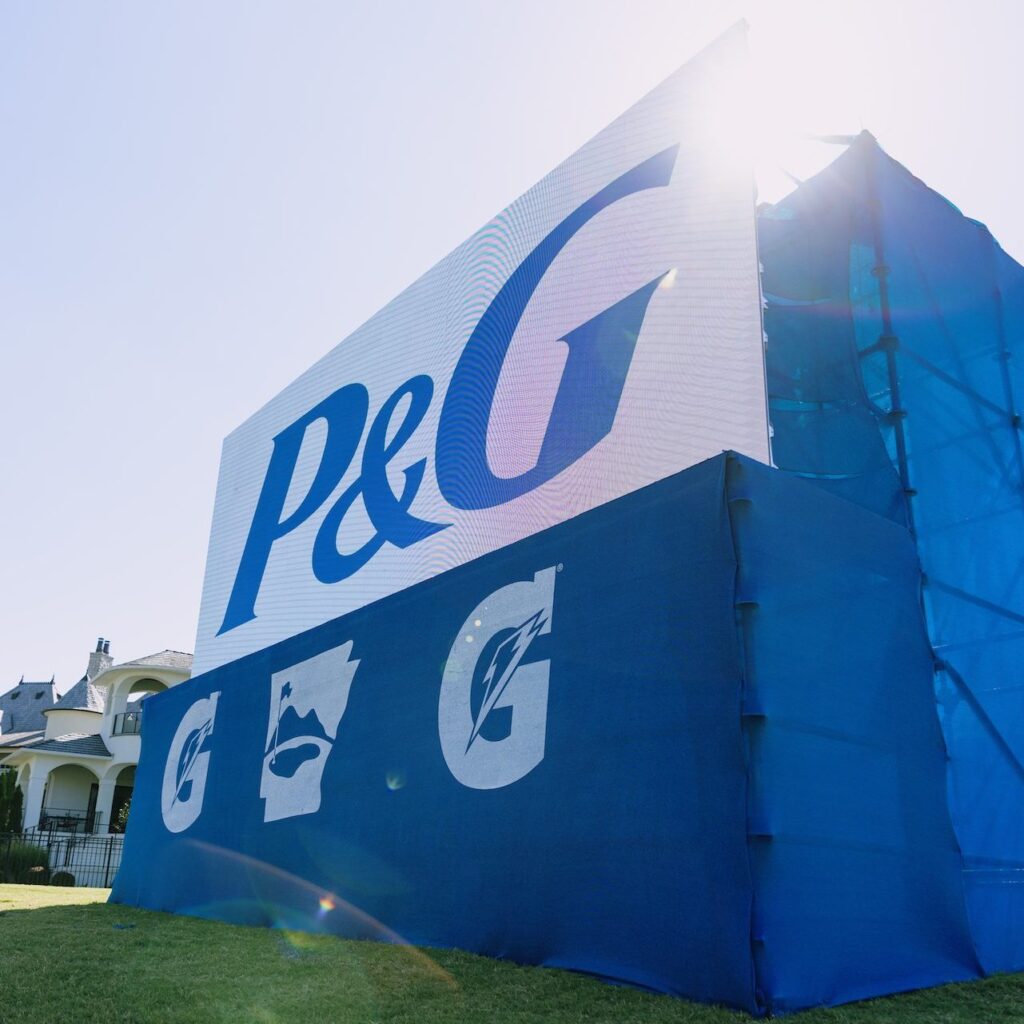 A large l.e.d. screen displays P and G logo while sitting on a golf course