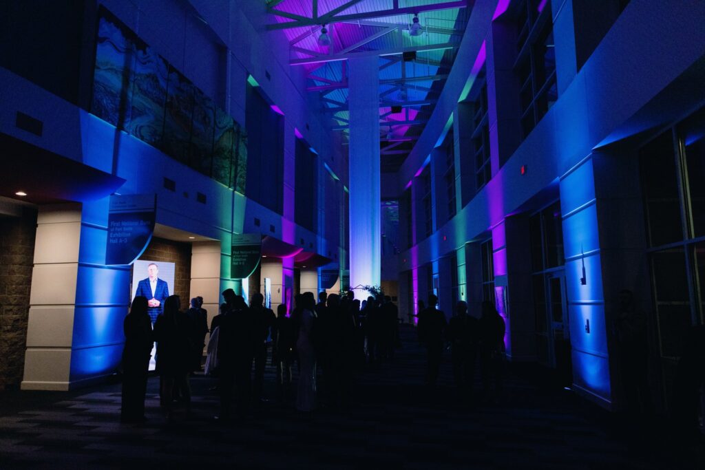 Red, purple, and blue uplights surround a lobby area.