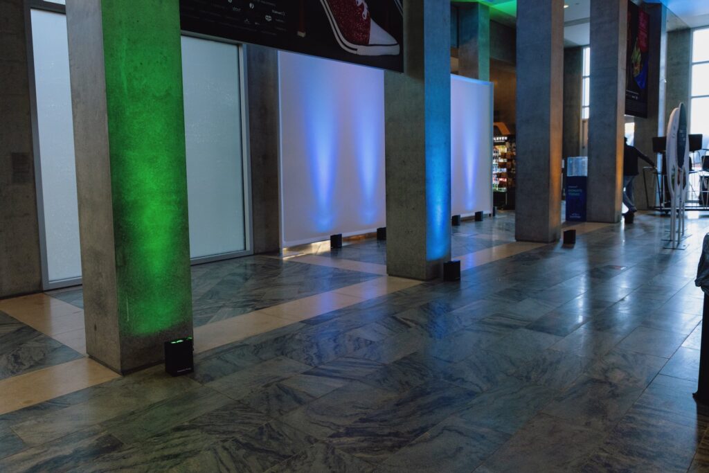 Blue and green uplighting lines a lobby.