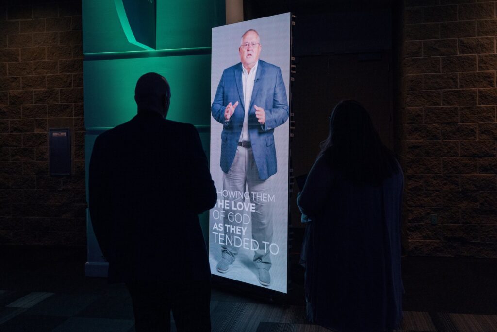 The silhouette of a man stands next to a 7 foot tall LED panel.